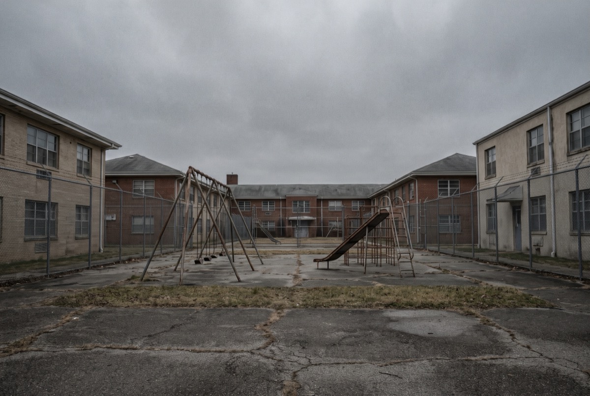 Empty fenced courtyard of a mid-century county children's institution, the era of the MacLaren Hall and juvenile hall claims in the LA County settlement